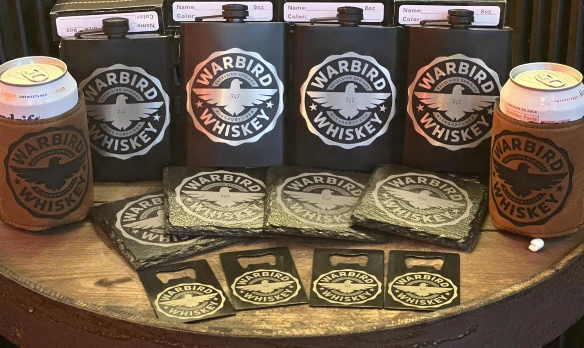 Assorted flasks, coasters, can coolers and bottle openers with "Warbird Whiskey" design